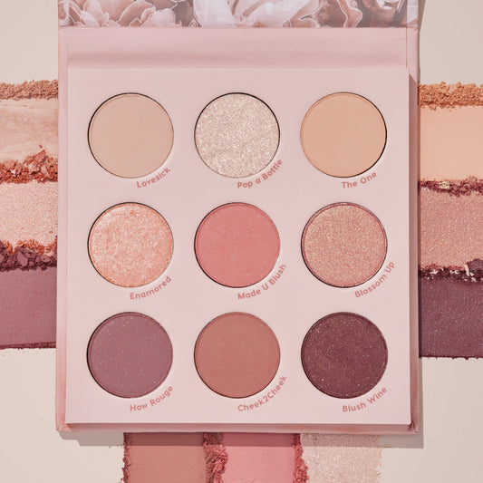 Blushing Nude ColourPop Shadow Palette Set showcases nine rosy neutral eyeshadows - matte, shimmer, and metallic - in a pink compact with shade names like Pop a Bottle and Blush Wine, shown over coordinating swatches for color payoff.