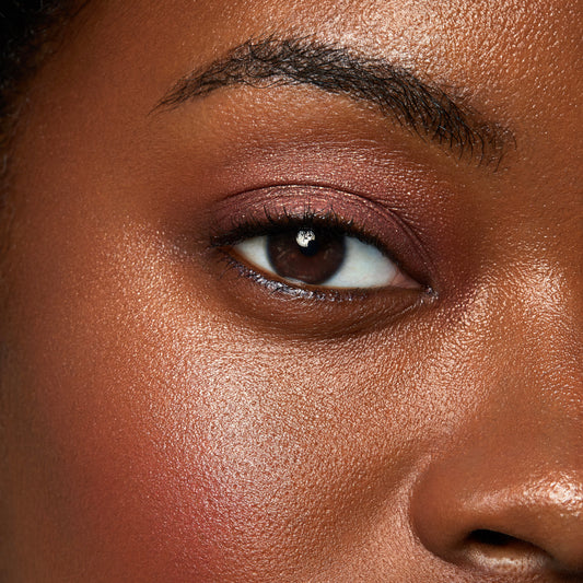 ColourPop DGAF Super Shock Shadow eyeshadow swept across a model's eyelid, warm copper-brown shimmer with fine gold sparkle blended from lash line to crease, shown in a tight eye close-up under soft lighting.