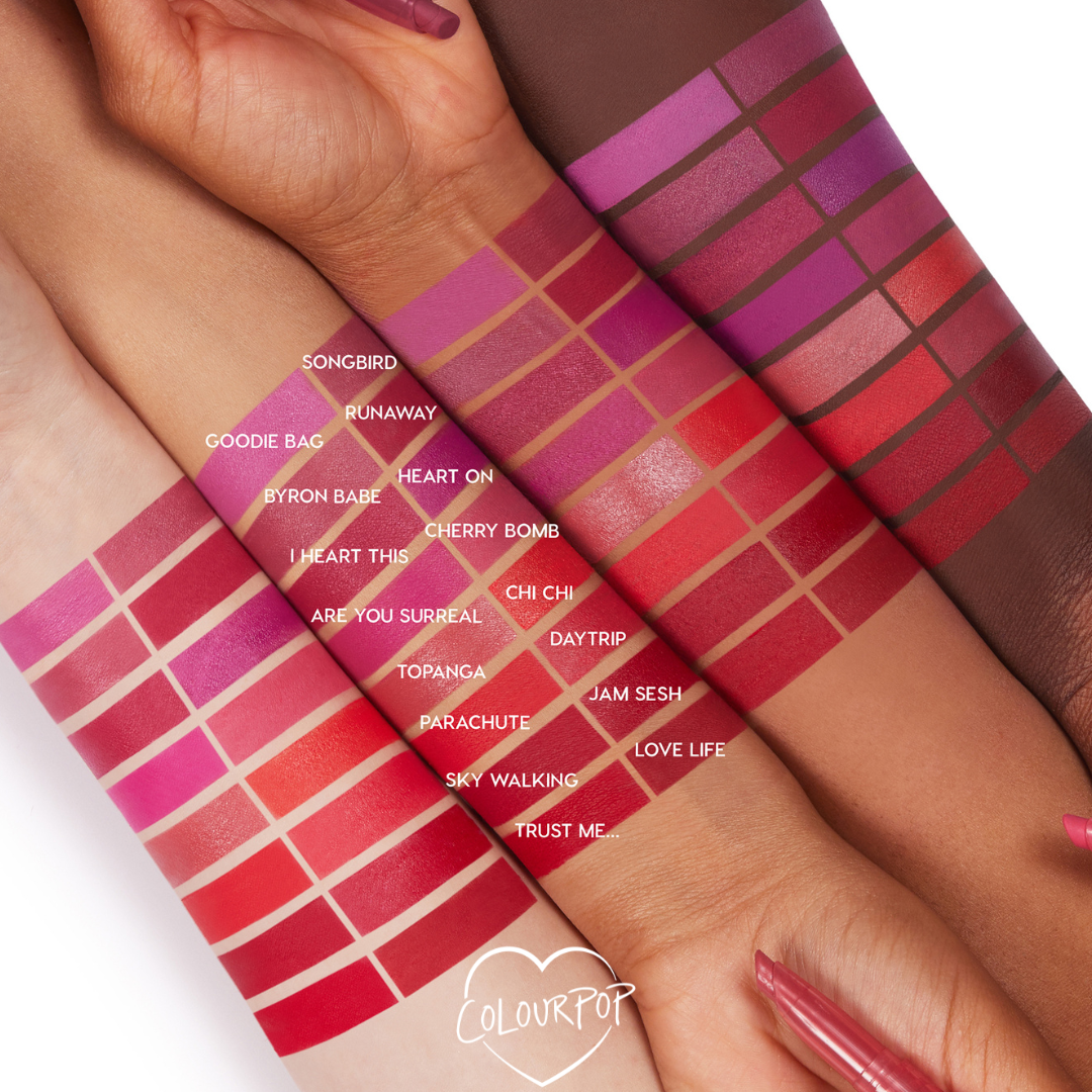 Chi Chi Lippie Stix swatched on multiple arms, showing a bright orange-red stripe among labeled reds and pinks to compare payoff on light to deep skin tones; ColourPop Lippie Stix shade chart for choosing the Chi Chi color.