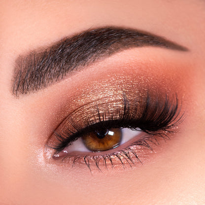 Shimmering copper-bronze eye shadow blends across a closed lid with fluttery lashes, showcasing warm nude tones created with the Nude Mood ColourPop Shadow Palette, featuring a soft matte crease and glowing inner corner highlight.