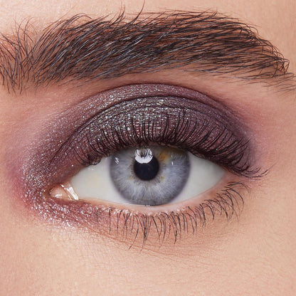 Shimmery plum eyeshadow sweeps across the eyelid, showcasing ColourPop Bae Super Shock Shadow on a close-up eye with defined lashes and brow, highlighting metallic sparkle, smooth blend, and rich payoff for a bold evening makeup look.