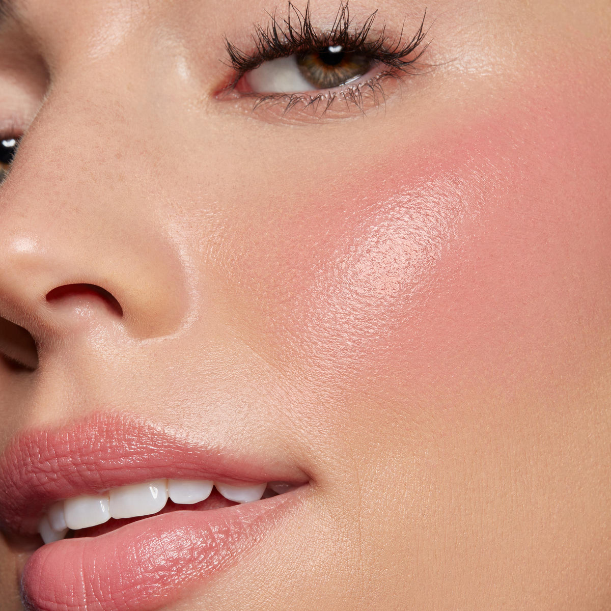 Adore You ColourPop Lip and Cheek Balm giving a dewy pink flush on the cheek and a soft glossy tint on the lips, shown in an extreme close-up of a model’s face to highlight the smooth, hydrated finish and natural, buildable color.