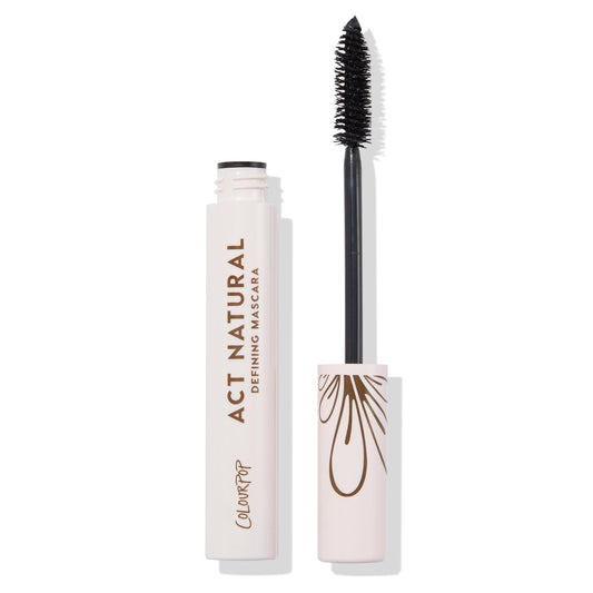 ColourPop Act Natural Mascara in Black shown open, wand coated in black formula beside a pale pink tube with bronze Act Natural Defining Mascara lettering and a floral cap graphic, on a white studio background.