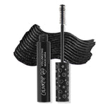 ColourPop BFF Mascara Black on Black displayed open, wand upright showing dense bristle brush, with a bold black swatch behind; sleek black tube reads Volumizing Mascara and cap features white heart, star, and smiley icons.