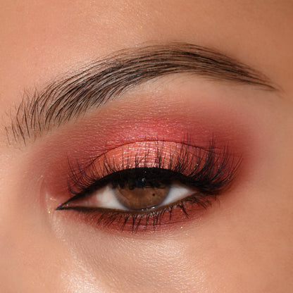 Shimmering coral-pink and berry eyeshadow sweeps across a brown eye with winged black liner and full lashes, showcasing the Baby Got Blush ColourPop Shadow Palette Set; close-up highlights metallic lid, soft matte crease, and groomed brow.