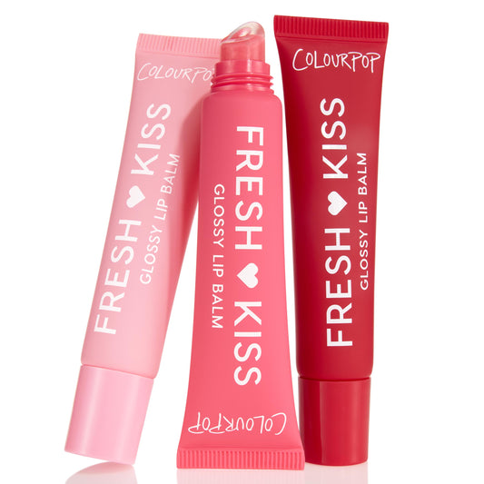 ColourPop Glossy Lip Balm Trio Fruit Basket shows three Fresh Kiss tubes - pastel pink, bright pink uncapped with slanted applicator, and deep red - standing side by side on a white background with white branding.