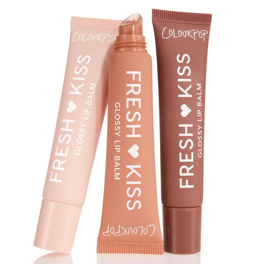 Sweet Treats ColourPop Glossy Lip Balm Trio standing in a fan: three Fresh Kiss squeeze tubes in blush pink, peach, and cocoa, center tube uncapped showing slanted applicator, set against a clean white background.