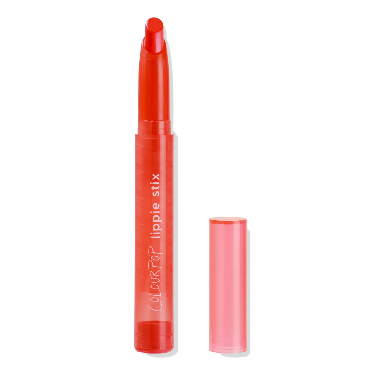 ColourPop Lippie Stix in Chi Chi stands uncapped with its slanted orange-red bullet exposed, the translucent coral tube shows COLOURPOP lippie stix branding, while the cap rests beside it on a white background.