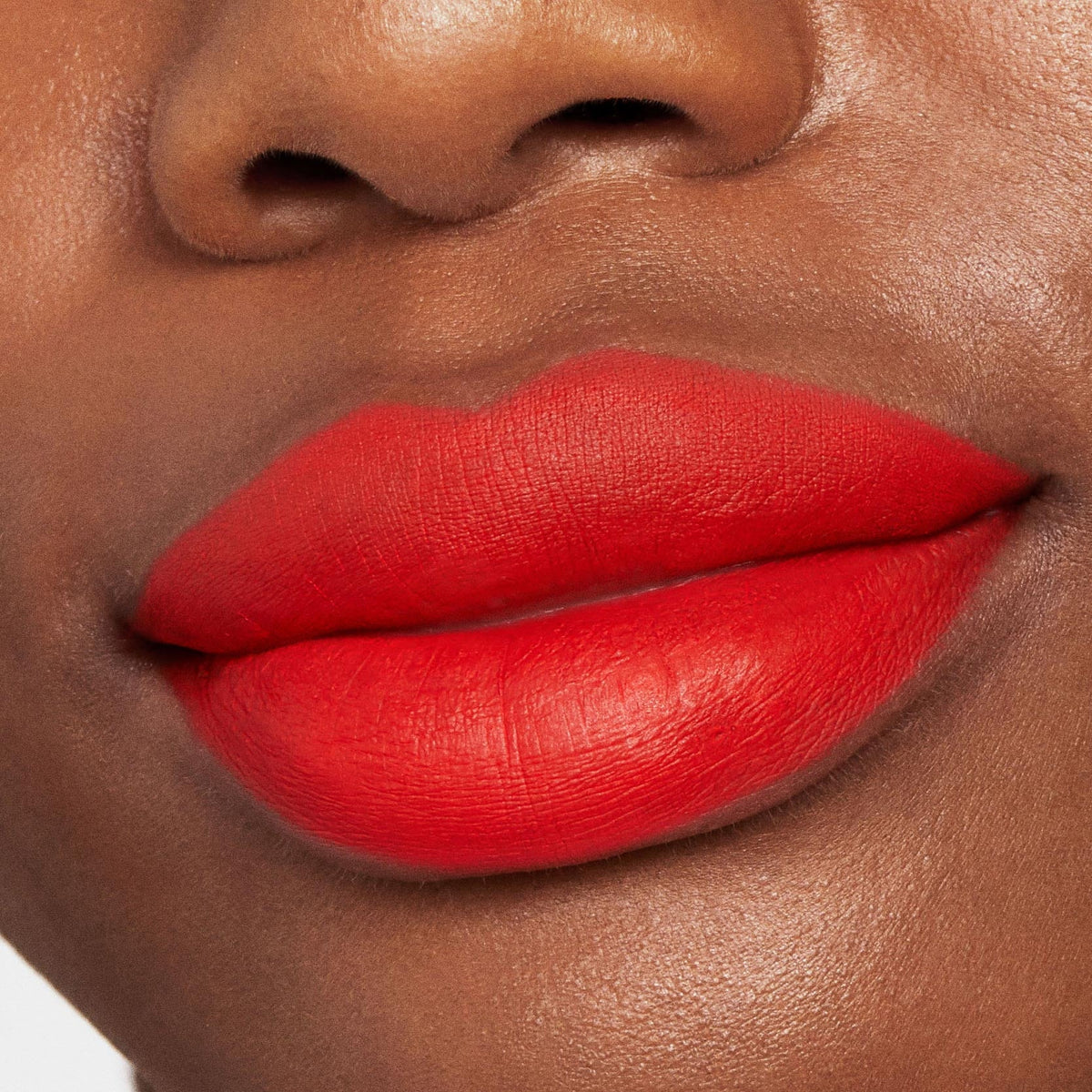 Bold matte orange-red lips showcase Chi Chi Lippie Stix in full coverage, highlighting a smooth, velvety finish on deep skin in a tight beauty close-up, perfect to pair with a ColourPop Lippie Pencil for crisp, defined edges.