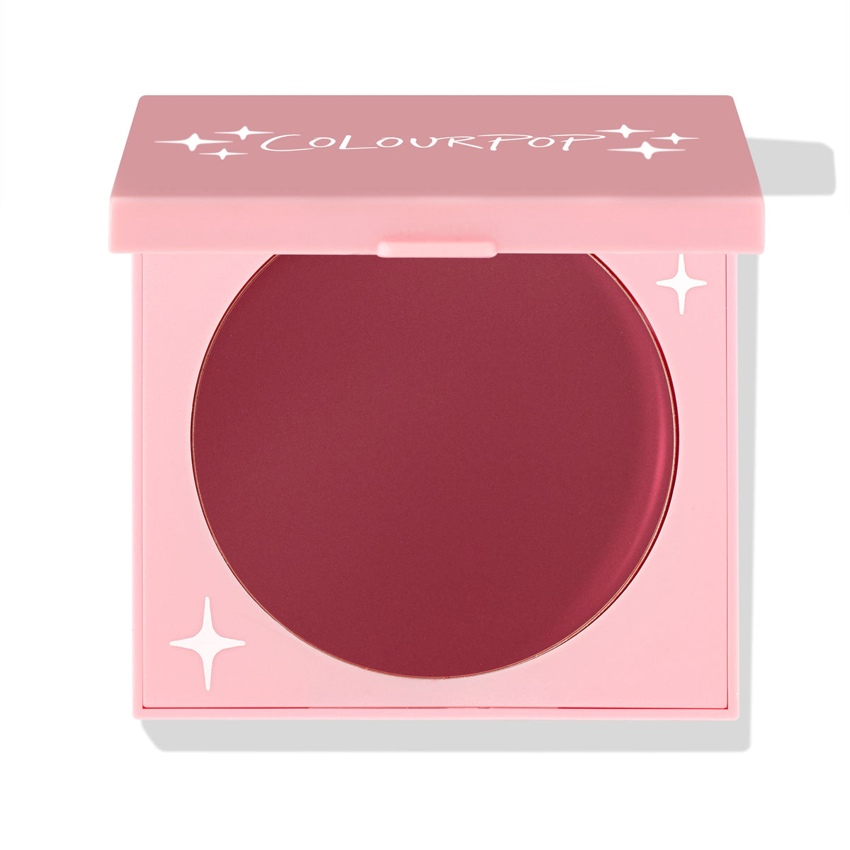 ColourPop Coyote cream blush compact sits half-open, revealing a deep berry pan in a pink square case with white star accents and ColourPop logo; matte cream formula for cheeks; ColourPop Cream Blush on a white background.