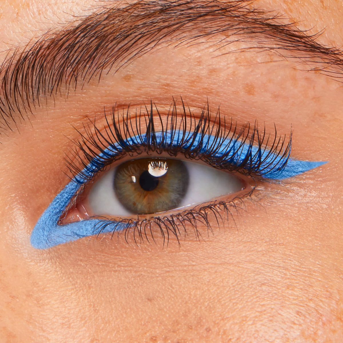 Prance ColourPop Crème Gel Liner tracing a vivid sky-blue graphic wing along the upper and lower lash lines, creating a sharp cat-eye on a close-up eye with long lashes.