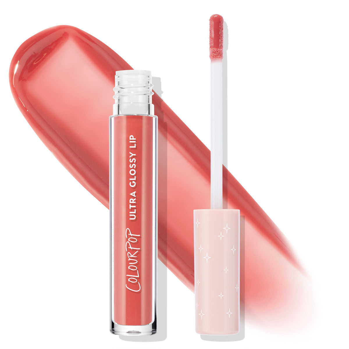 ColourPop Ultra Glossy Lip in Ditto stands open, showing a doe-foot applicator with a blush star-print cap beside a wide peachy-coral swatch, the clear tube revealing the high-shine pigment on a clean white background.