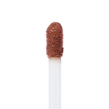 Doe-foot applicator swiped with Espresso Martini, a warm coffee-brown ColourPop Ultra Blotted Lip, showing diffused pigment and plush texture in a macro close-up on a white background.
