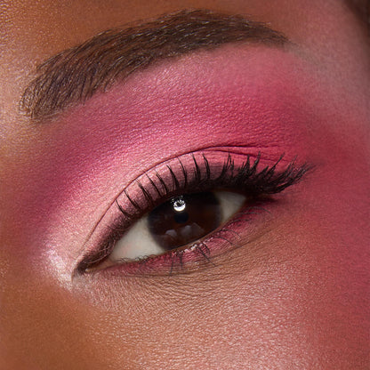 Close-up eyelid wears sunset pink and coral shimmer, softly blended to the brow with defined lashes, showcasing the ColourPop Beach Dreamin' shadow palette pigments in a bold, summer-ready eye look.