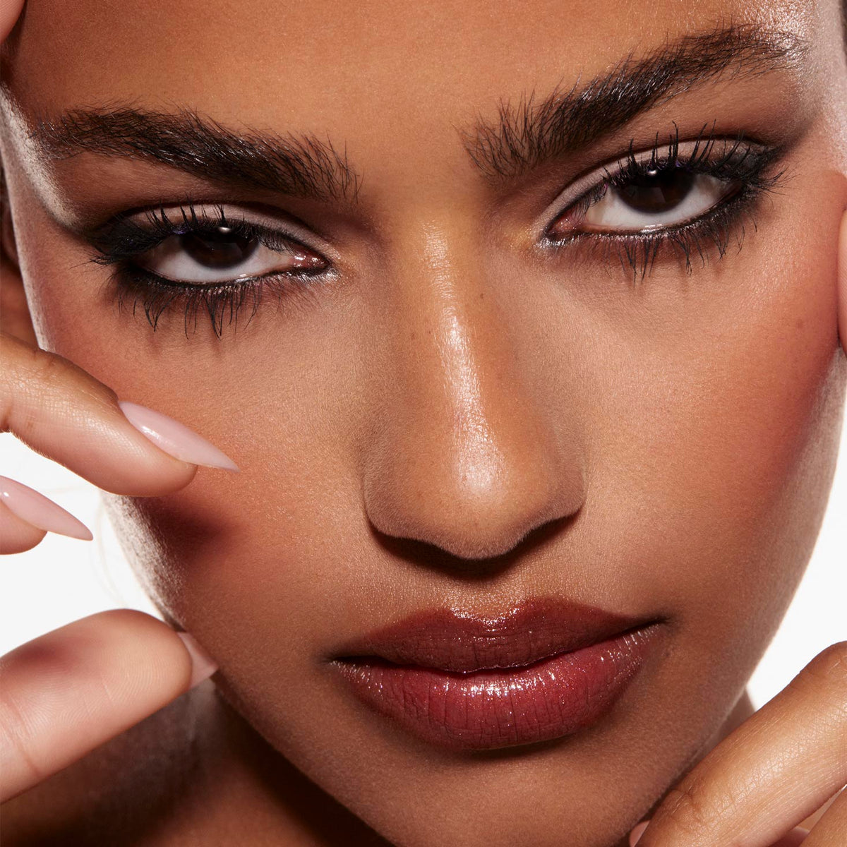Smoky taupe-and-charcoal eye look created with the Stone Cold Fox Shadow Palette, a ColourPop Shadow Palette, defining the model’s eyes with black liner and long lashes in a tight studio close-up with nude-gloss lips and manicured fingers framing.