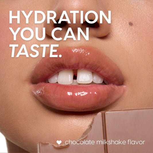 Glossy, hydrated lips coated with the Triple Chocolate ColourPop Lip Care Kit, delivering chocolate milkshake flavor and high shine, with a broken chocolate bar at the lower edge in a tight, close-up beauty shot.