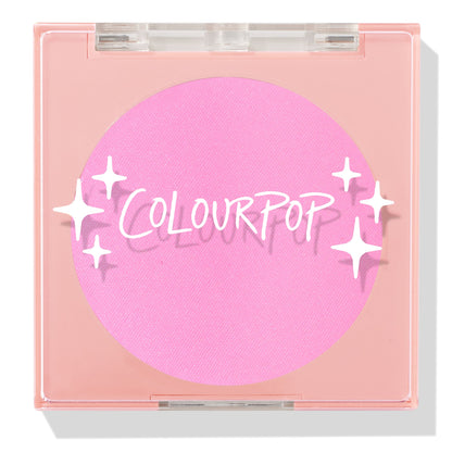 ColourPop Pressed Powder Blush in Flamingo shows a vibrant hot pink pan inside a square peach compact with a clear lid and white sparkles logo, closed and travel-friendly on a light background.