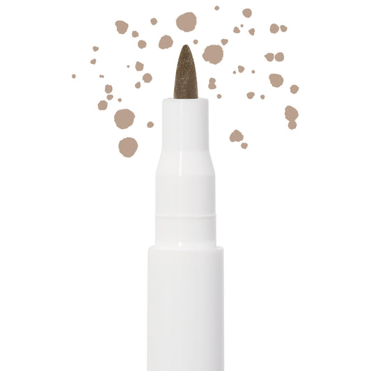 Soft Brown freckle pen by Colourpop with a fine felt tip applying natural soft brown dots, shown close up against a white background to highlight precise faux freckle makeup for the face.