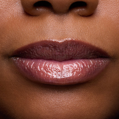 Close-up swatches of Colourpop Fresh Kiss Glossy Balm in Chocolate Cherry on lip tones, showing sheer berry shine with subtle shimmer, promoting Lip Gloss & Lip Oil finish and smooth, hydrated lips.