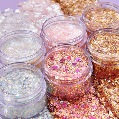 Disco Lady ColourPop Glitter Gel gleaming in open clear jars, swatched around them; iridescent silver, pink, and gold glitter with chunky flakes and heart confetti for face and body looks, styled on a pastel backdrop.
