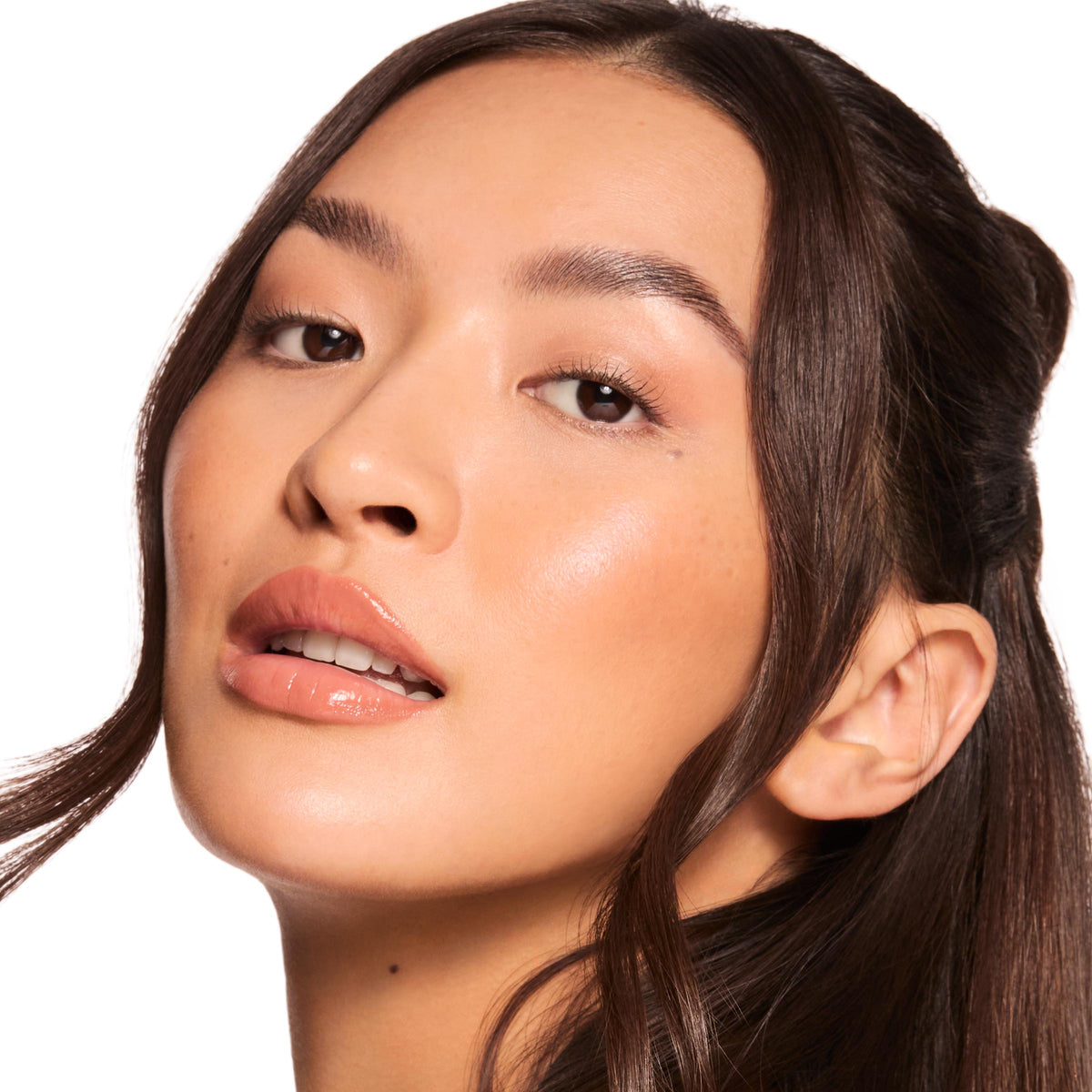 Model’s lips wearing a glossy caramel nude, highlighting ColourPop Gloss Goals Full Collection Set shine; lips softly parted with a smooth, hydrated finish, shown in a studio close-up against a white background.