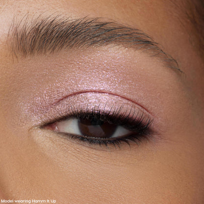 Shimmery pink ColourPop Jelly Much Shadow in Play All Day coats a model’s eyelid, catching light with a wet-look metallic finish; macro close-up shows soft lashes and groomed brow for a wearable, everyday eye makeup look.
