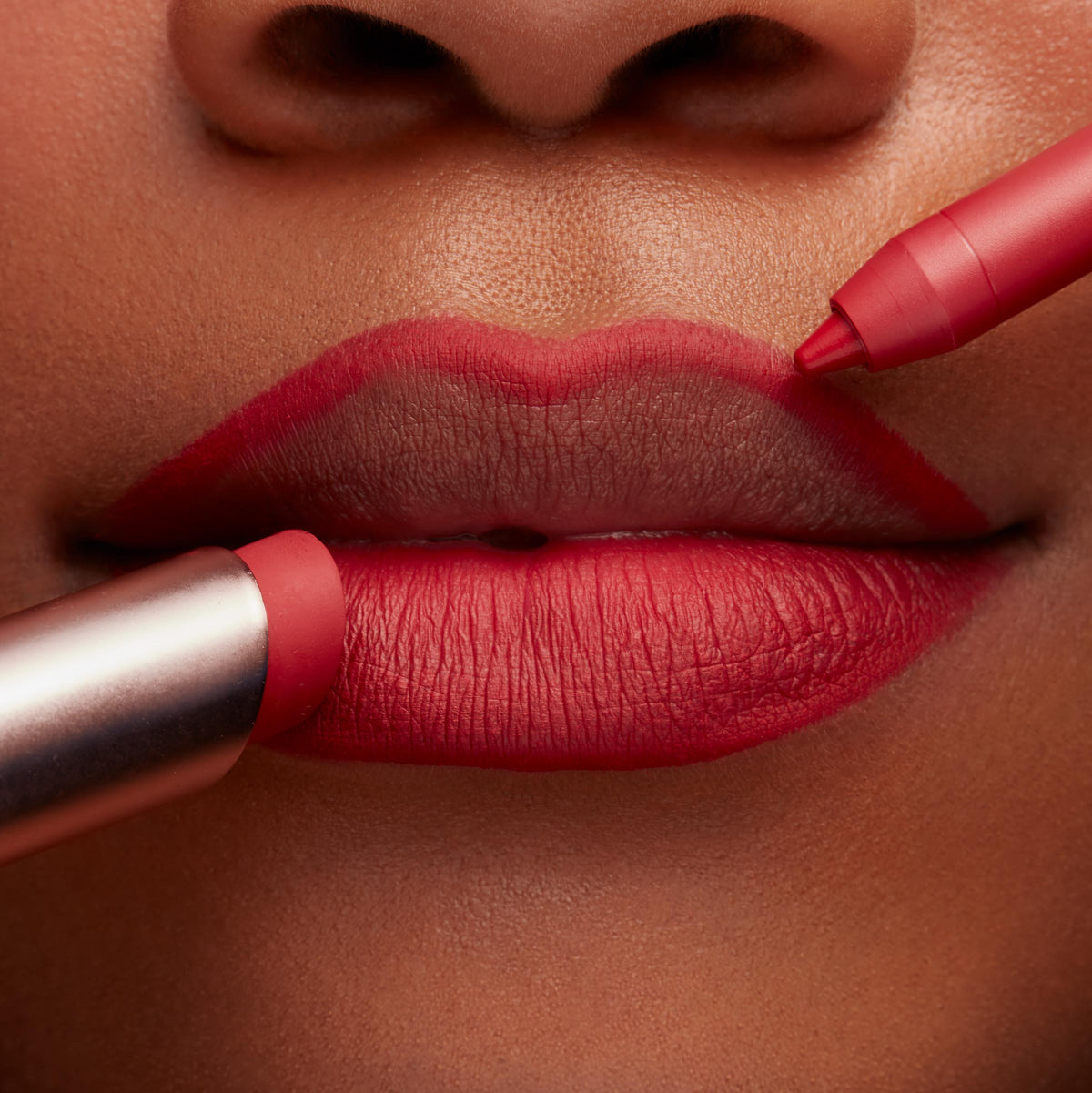ColourPop Lippie Pencil in Bossy lining lips in a crisp, vivid red while a matching lipstick fills the bottom lip, shown in an extreme close-up for precise definition and creamy matte payoff.