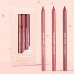 Pinky Promise ColourPop Lippie Pencil trio stands upright, three creamy lip liners in nude pink, rosy coral, and mauve berry beside a blush, star-embossed box on a pastel pink backdrop, limited edition set.
