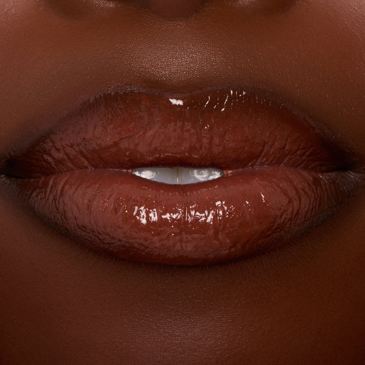 Glossy lips wearing ColourPop Ultra Glossy Lip in Coffee Break, a rich coffee‑brown creme shade, reflecting high shine in a tight close-up studio shot.