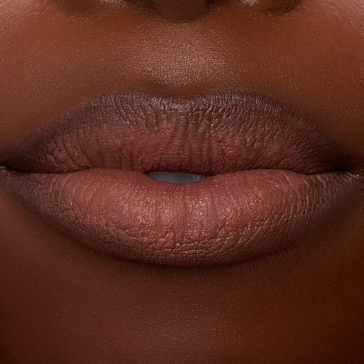 Close-up lips wearing ColourPop Ultra Blotted Lip in Espresso Martini, a coffee-brown shade with a soft-matte, blotted finish and gently diffused edges, shown in studio lighting to showcase the lightweight, blurred-effect formula.