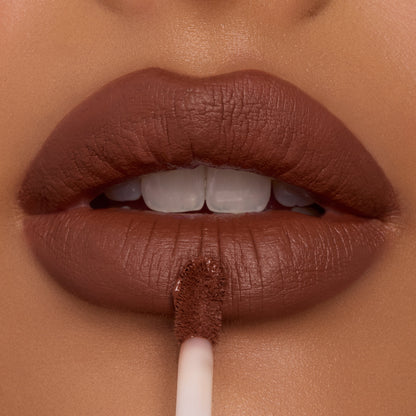 Full lips apply Espresso Martini Ultra Blotted Lip with a doe-foot applicator, revealing a soft-matte, blurred finish in a rich cocoa-brown shade; close-up of ColourPop Ultra Blotted Lip on warm skin.