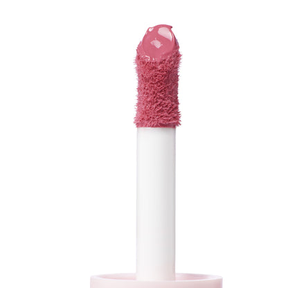 Doe-foot applicator coated in IKTR ColourPop Liquid Blush, a rosy pink liquid blush, lifted from a pale pink cap against a clean white background, highlighting the plush flocked tip and creamy texture for precise, buildable cheek color.