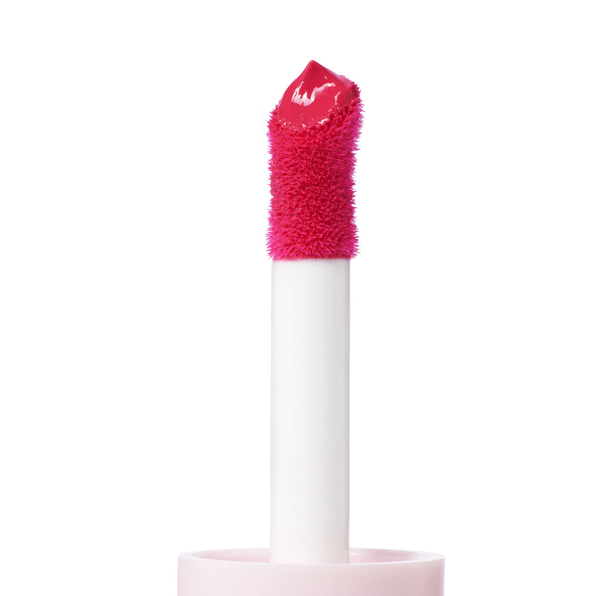 Doe-foot applicator coated in Wildest Dreams ColourPop Liquid Blush, a vivid hot-pink cream, held on a white wand with soft flocked tip against a clean white background, highlighting glossy, high-pigment texture for cheeks.