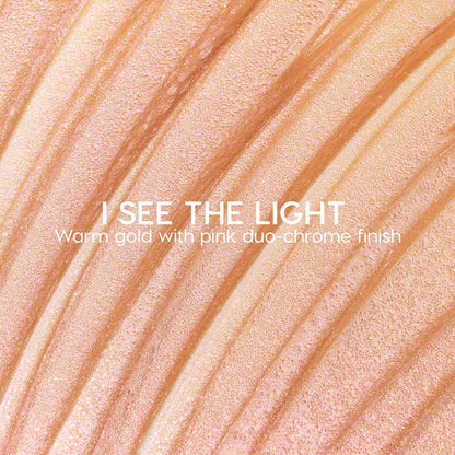 I See the Light ColourPop Liquid Highlighter swatched in sweeping ridges, showing a warm gold base with pink duochrome shimmer; creamy liquid texture gleams under light in a close-up macro for a luminous glow.