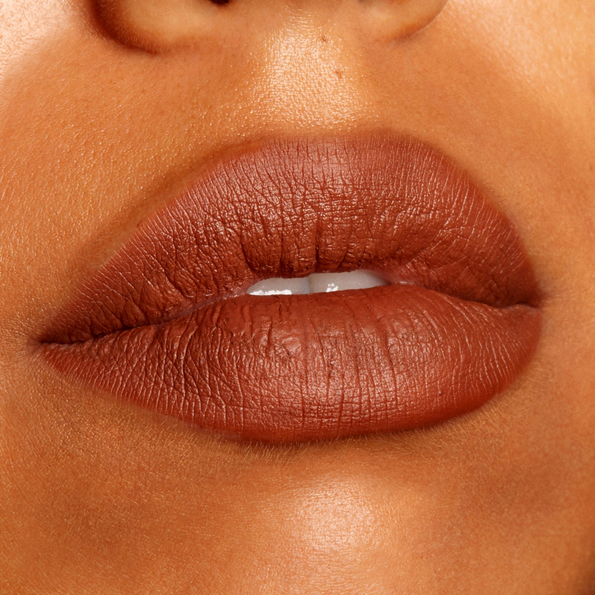 Full lips lined and filled with ColourPop Lippie Pencil BFF3, a warm cinnamon-brown matte lip liner, shown in a close-up swatch on medium‑deep skin with crisp edges and smooth coverage.