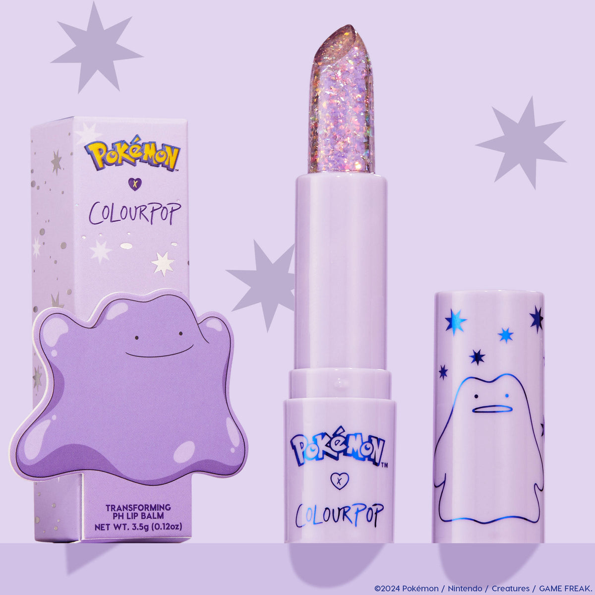 ColourPop pH Lip Balm Transform shown uncapped, revealing a clear glittery bullet, positioned between its lilac starry box and matching cap featuring Ditto from the Pokémon collab on a pastel purple background.