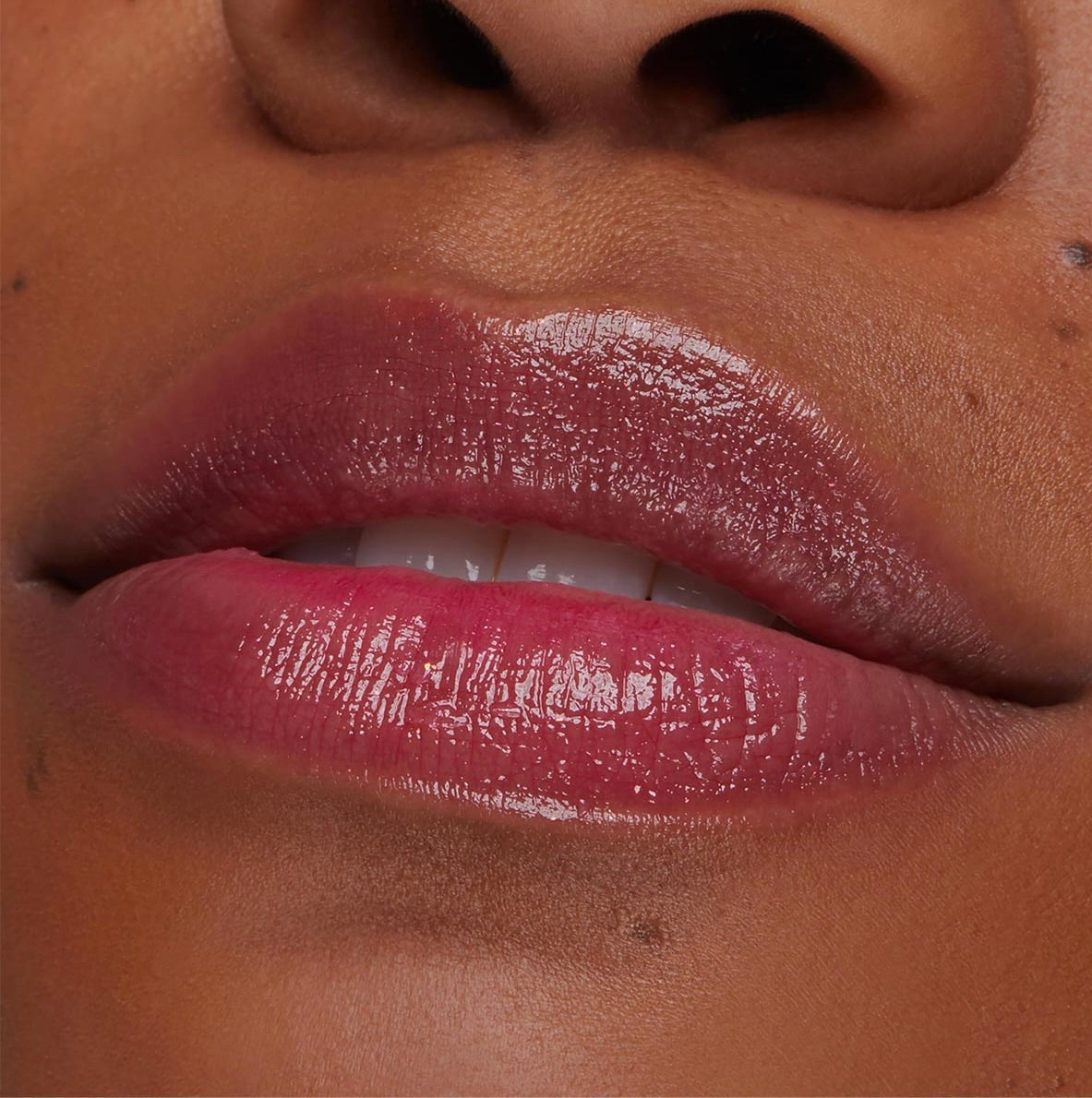 Glossy lips wearing Transform pH Lip Balm reveal a color-changing rosy pink tint and hydrated shine in a close-up lip swatch, showcasing the smooth, cushiony finish of the ColourPop pH Lip Balm.
