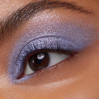 Dream Much ColourPop Super Shock Shadow, a cream-to-powder formula, shimmers across the eyelid in a metallic lavender-periwinkle wash, smoothly blended from inner corner to crease in a close-up eye makeup swatch.