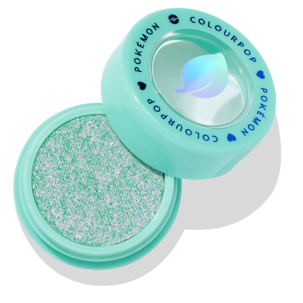 Solar Beam ColourPop Super Shock Shadow sitting open to reveal a sparkling mint-green and pink duochrome eyeshadow, in a mint compact with clear lid and blue COLOURPOP POKÉMON lettering and leaf icon.