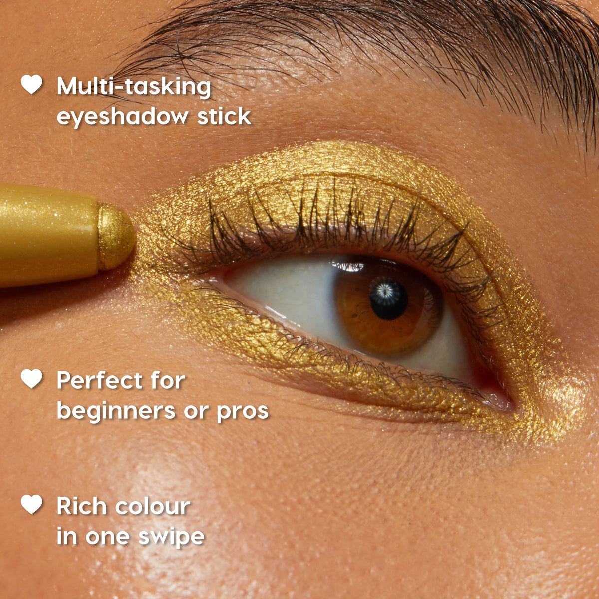 ColourPop Shadow Stix in Cool Metallics glides across a single eyelid, laying down rich, shimmering gold pigment in one swipe; close-up shows the creamy eyeshadow stick tip and smooth metallic payoff.