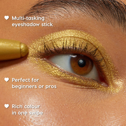 ColourPop Shadow Stix in Cool Metallics glides across a single eyelid, laying down rich, shimmering gold pigment in one swipe; close-up shows the creamy eyeshadow stick tip and smooth metallic payoff.