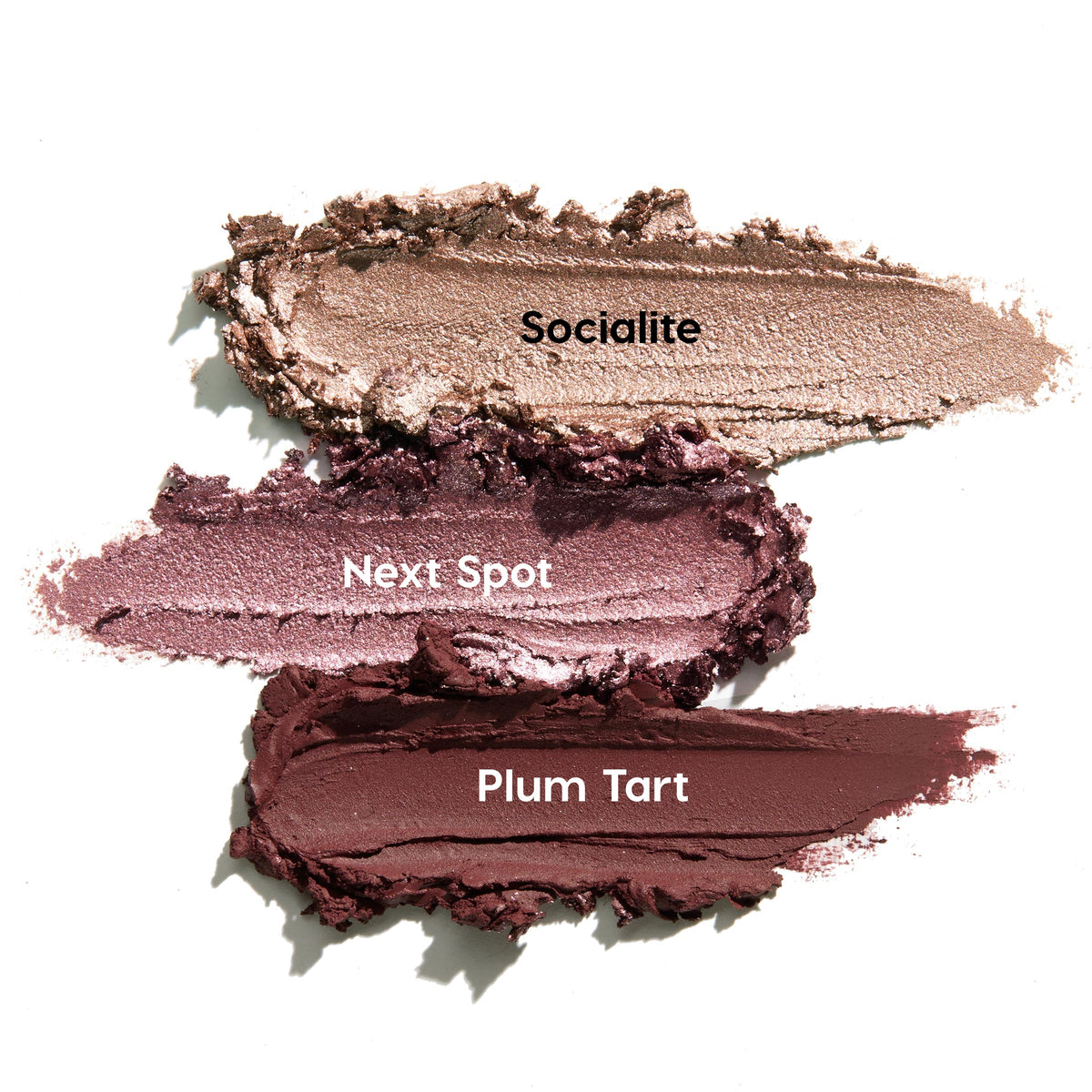 Three ColourPop Shadow Stix swatches from the Rose Goals set - Socialite, Next Spot, and Plum Tart - spread in thick strokes on a white background, showing creamy texture with champagne shimmer, metallic mauve, and deep matte plum.