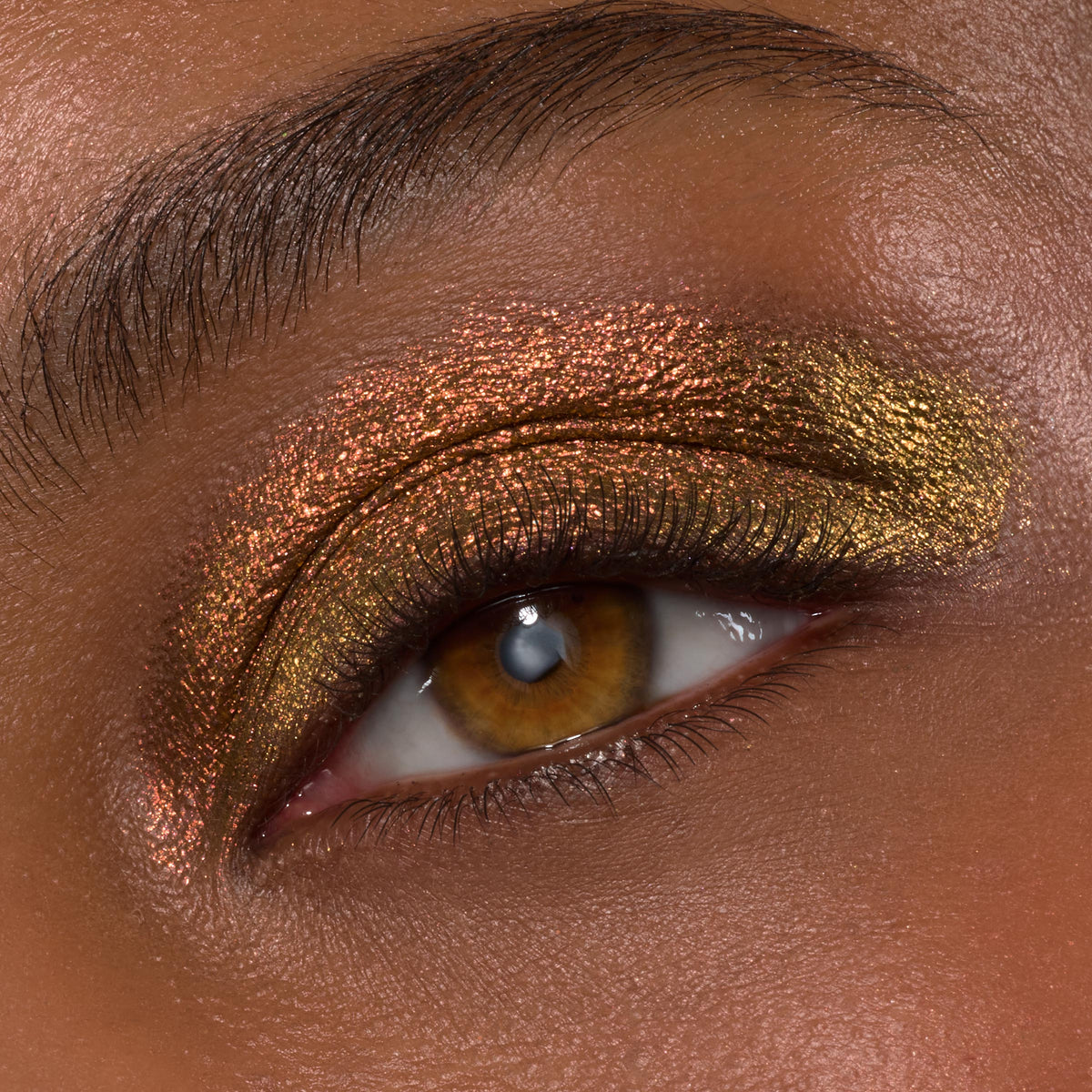 Wolf Girl ColourPop Shadow Stix creates a molten copper-to-gold duochrome on the eyelid, shimmering across the lid and crease with fine sparkle and defined lashes, macro beauty shot showing product payoff and metallic finish.