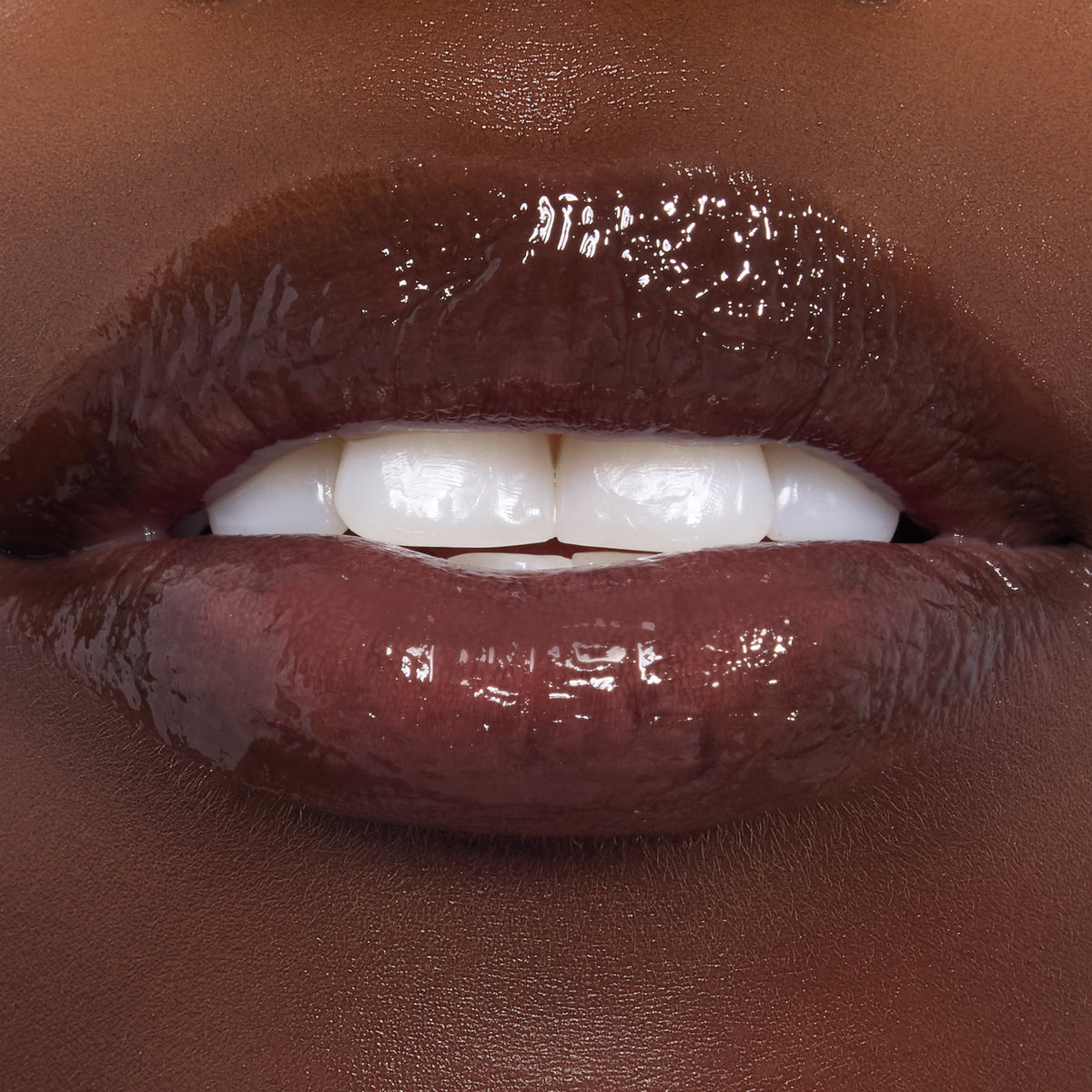 Glistening lips wear Gumdrop Buttons, a rich cocoa-brown ColourPop Candy Lip Oil, showing high-shine, smooth hydration and semi-sheer pigment in a close-up beauty swatch.