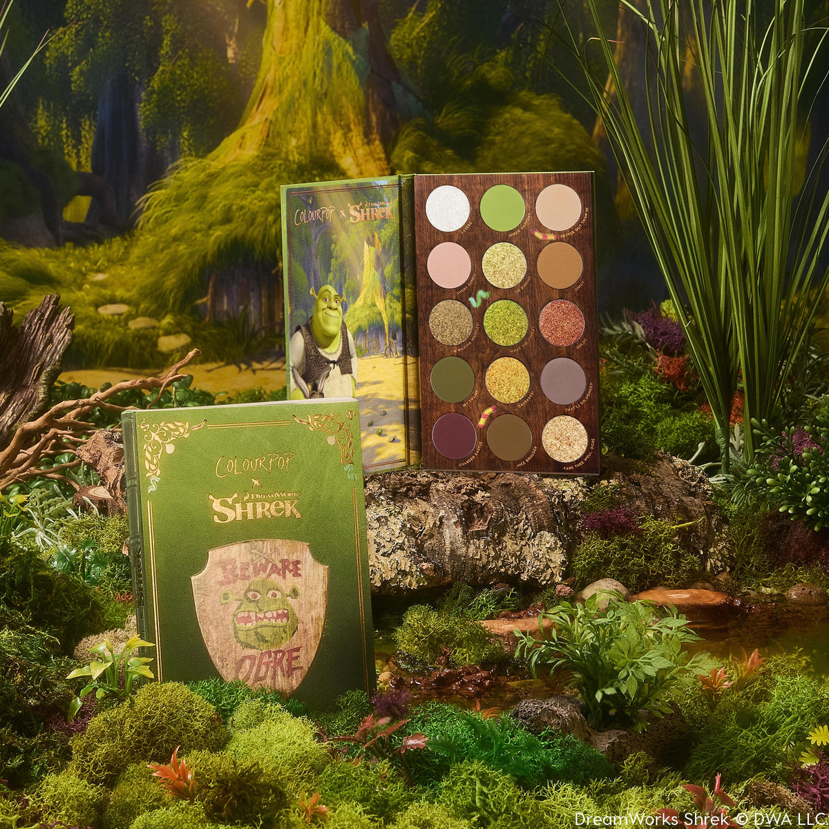 ColourPop Shadow Palette Beware Ogre opens to display 15 earthy green, brown, and gold mattes and shimmers, paired with a matching green box and Shrek artwork, styled in a mossy swamp setting.