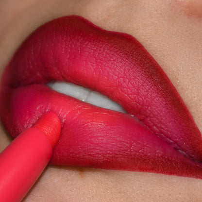 Bichette Lippie Pencil lines and fills lips in vivid cherry‑red with pink undertones; close‑up shows the creamy ColourPop Lippie Pencil tip tracing the lower lip for sharp edges and a smooth, matte, smudge‑resistant finish.