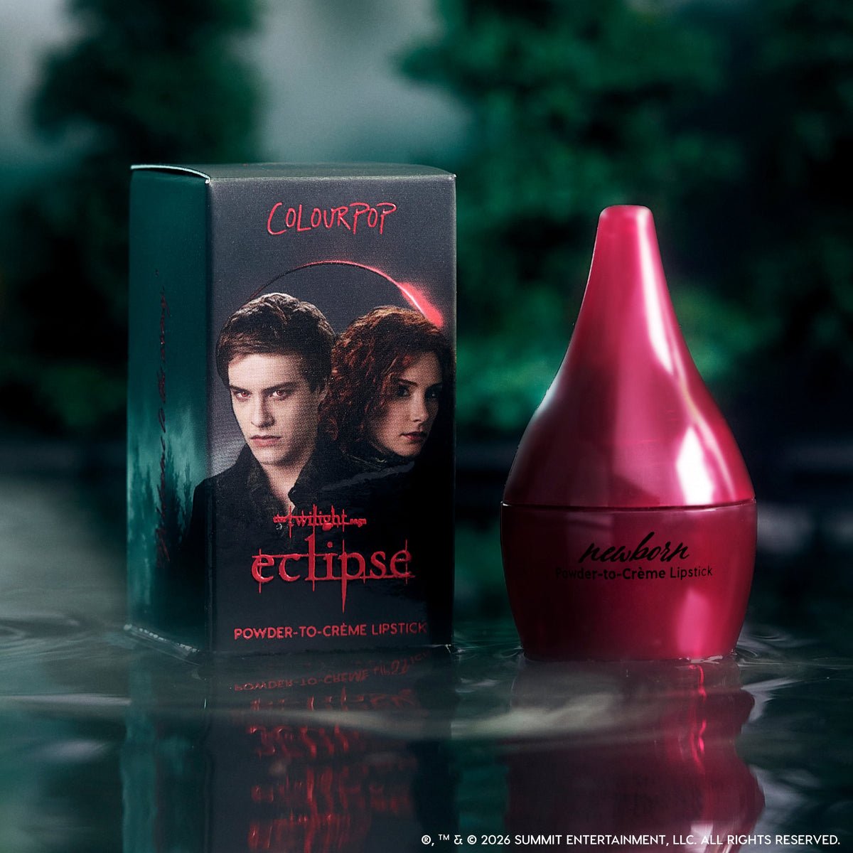 ColourPop Newborn powder to creme lipstick from the Twilight Eclipse collection stands beside its dark forest-themed box with red logo and character art, reflected dramatically on misty water for a moody, cinematic beauty product shot.
