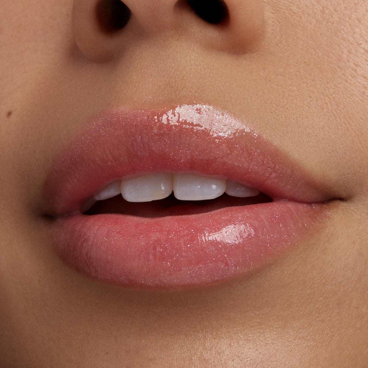 Lips wearing ColourPop Ultra Glossy Lip Yeehaw gleam with sheer pink micro-shimmer, highlighting a smooth, high-shine finish in a macro close-up against natural skin.
