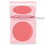 Whole Mood cream blush compact half-open, showing a round rosy-pink matte pan and mirror inside a pastel pink case with white star accents; ColourPop Cream Blush product.