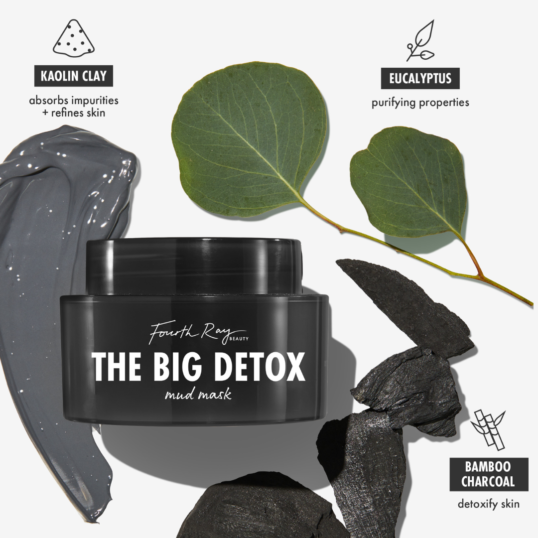 Black jar of Fourth Ray Beauty The Big Detox Mud Mask, a ColourPop Face Mask, centered with a glossy gray kaolin clay smear, eucalyptus leaves, and bamboo charcoal pieces, highlighting purifying, pore‑refining detox treatment for facial skin.